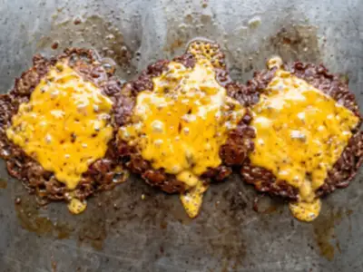 Concept imagery: three smash patties side by side on the griddle, each under bubbling melted cheese